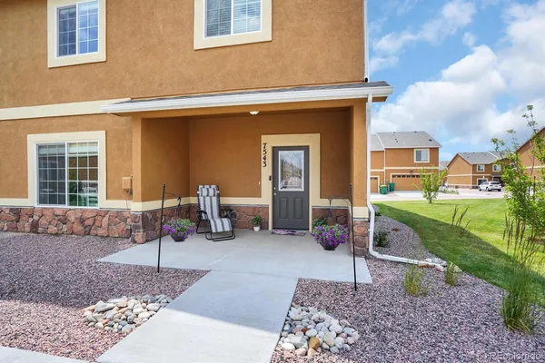a view of a house with backyard sitting area and garden
