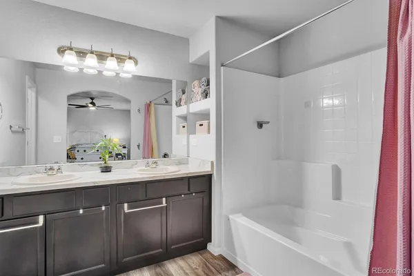a bathroom with a tub a sink and mirror