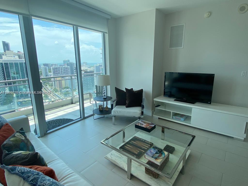 92 Southwest 3rd Street, Unit 3102 Miami, FL 33130 - Photo 3 of 15 a living room with furniture and a flat screen tv