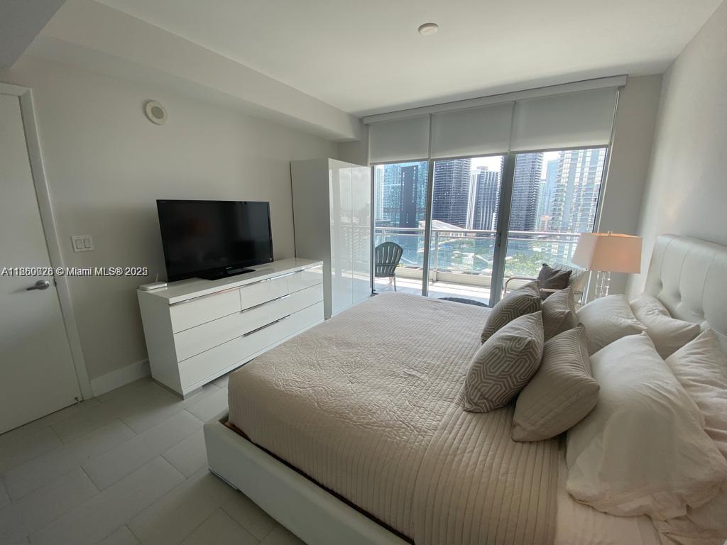 92 Southwest 3rd Street, Unit 3102 Miami, FL 33130 - Photo 4 of 15 a bedroom with a bed and large flat screen tv