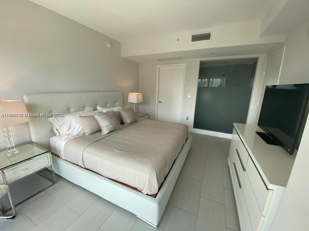 92 Southwest 3rd Street, Unit 3102 Miami, FL 33130 - Photo 5 of 15 a bedroom with a bed and a television