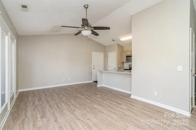 a view of an empty room and window and wooden floor