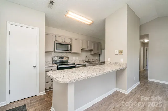 a kitchen with a sink a microwave a refrigerator and cabinets