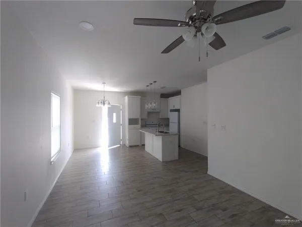 a view of a kitchen with a sink and dishwasher a refrigerator with wooden floor
