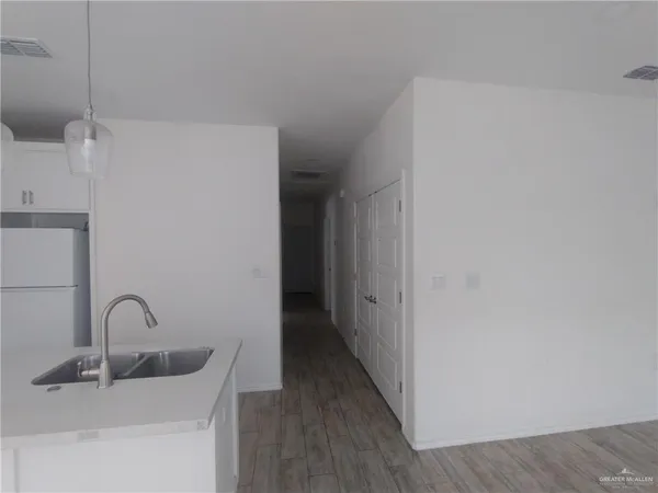 a kitchen with a sink and wooden floor
