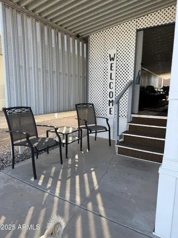 a view of a patio with table and chairs with wooden floor and book shelf