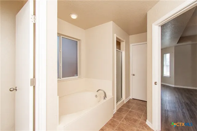 a bathroom with a tub shower and a sink