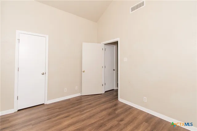 a view of an empty room with wooden floor