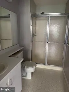 a bathroom with a granite countertop toilet and a sink