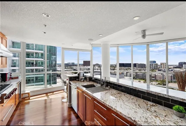 a large kitchen with a large counter top stainless steel appliances and cabinets