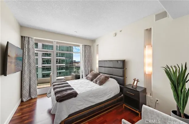 a bedroom with a bed and a potted plant on the dresser