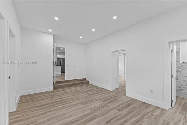 a view of an empty room with wooden floor and closet