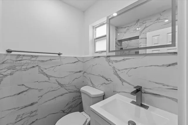 a bathroom with a sink a toilet and a mirror