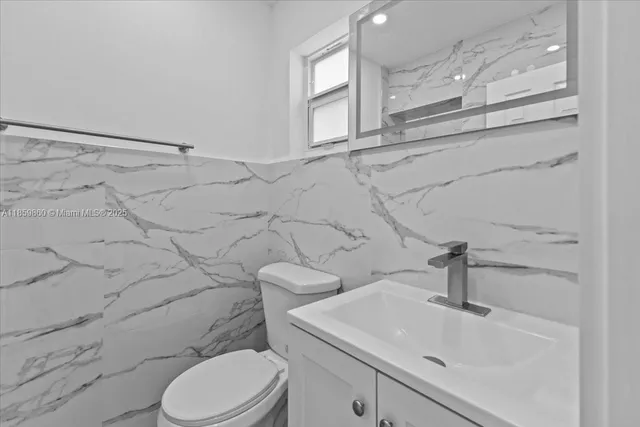 a bathroom with a sink mirror vanity and toilet