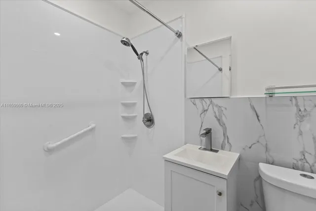 a bathroom with a sink a toilet and shower