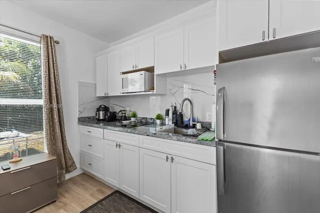 a kitchen with stainless steel appliances a refrigerator sink and cabinets
