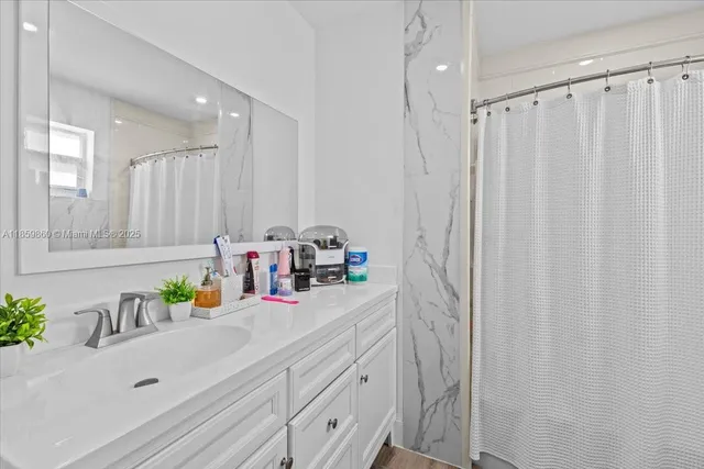a bathroom with a double vanity sink a vanity and a shower