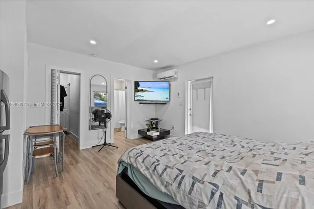 a bedroom with a bed and wooden floor