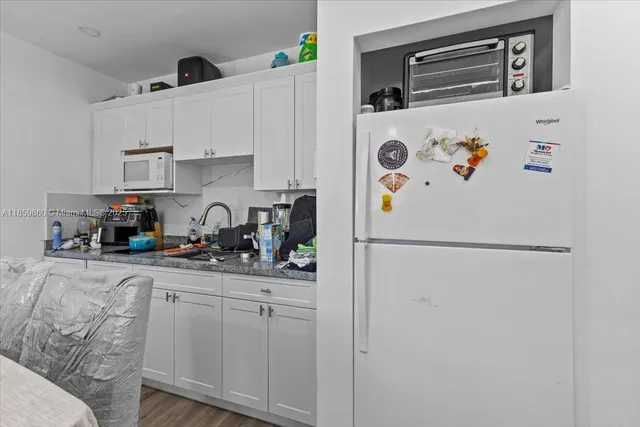 a white refrigerator freezer sitting inside of a kitchen