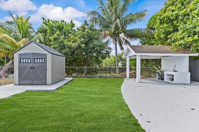 a view of a house with a yard potted plants and a large tree