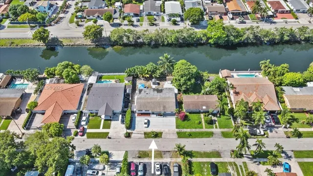 an aerial view of residential houses with outdoor space and lake view