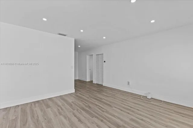 a view of an empty room with wooden floor