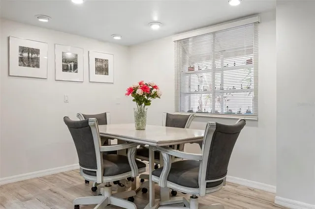 a kitchen with stainless steel appliances granite countertop table chairs sink and cabinets