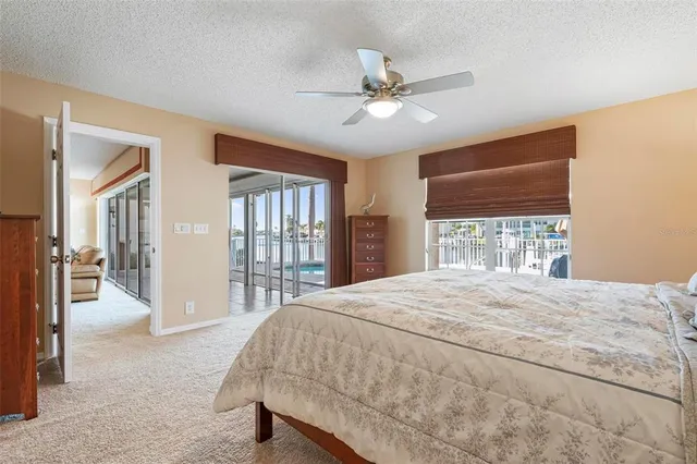 a bedroom with a large bed and two large window