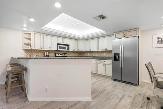 a kitchen with granite countertop white cabinets and stainless steel appliances