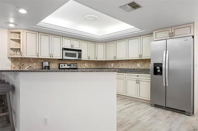 a kitchen with white cabinets and refrigerator