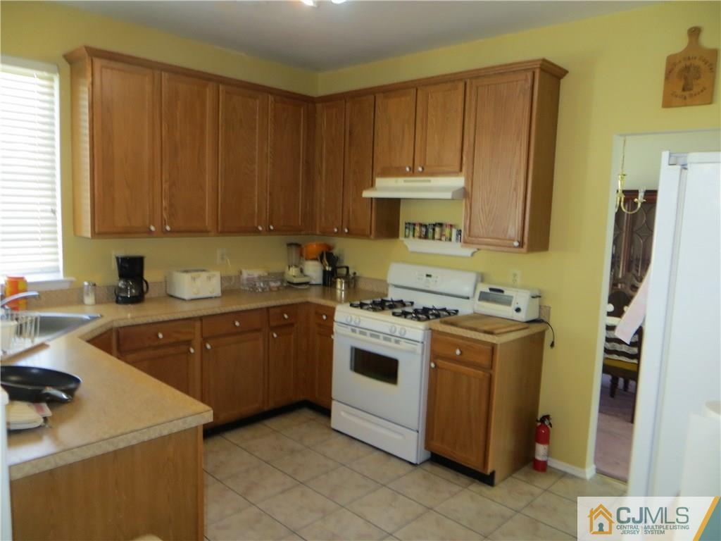 51 Stratton Road Old Bridge, NJ 07747 - Photo 7 of 25 a kitchen with a stove sink and cabinets
