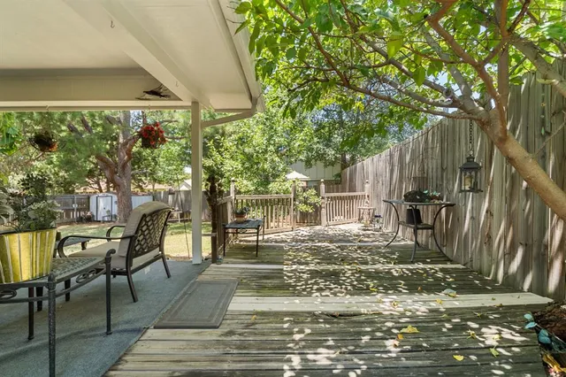 a view of a patio with table and chairs and wooden floor