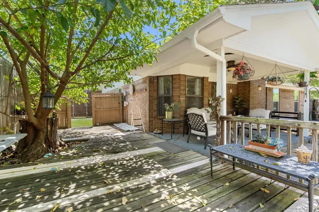a patio with table and chairs and potted plants
