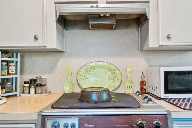 a kitchen with a stove and a white cabinets