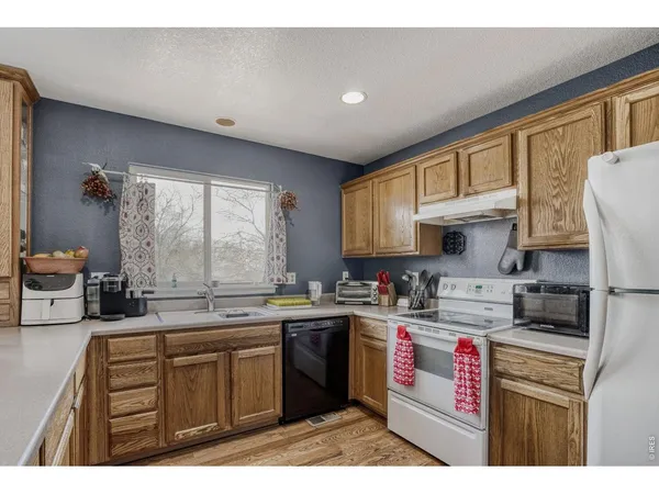 a kitchen with a sink a stove a refrigerator and cabinets