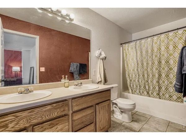 a bathroom with a sink a toilet a mirror and shower curtain