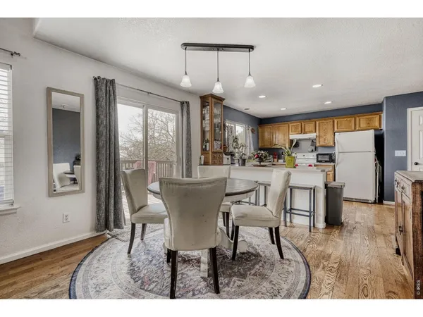 a dining room with furniture a chandelier and wooden floor