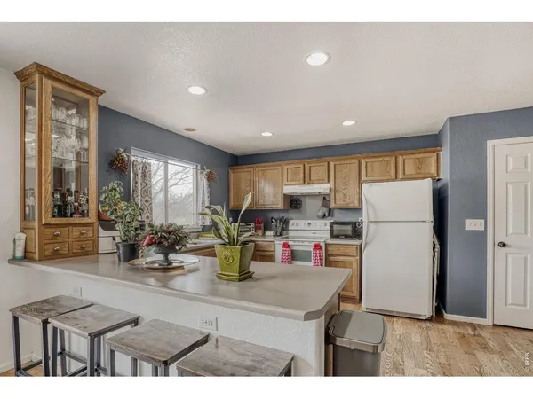 a kitchen with a refrigerator and a stove top oven