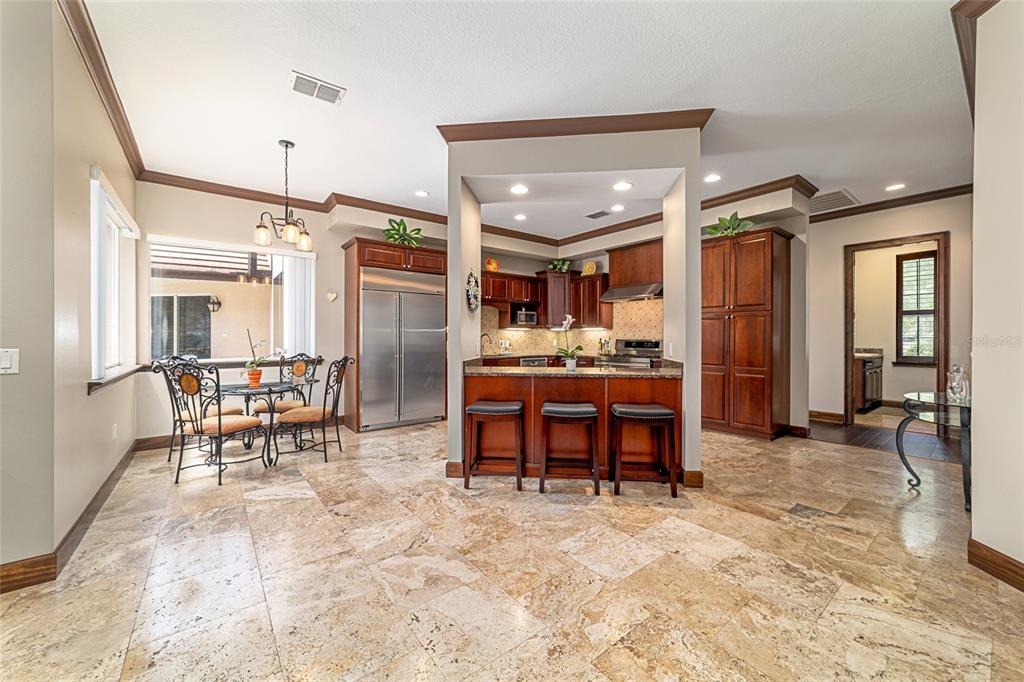 678 Southeast 47th Loop Ocala, FL 34480 - Photo 17 of 73 a kitchen with stainless steel appliances kitchen island granite countertop dining table chairs and a refrigerator
