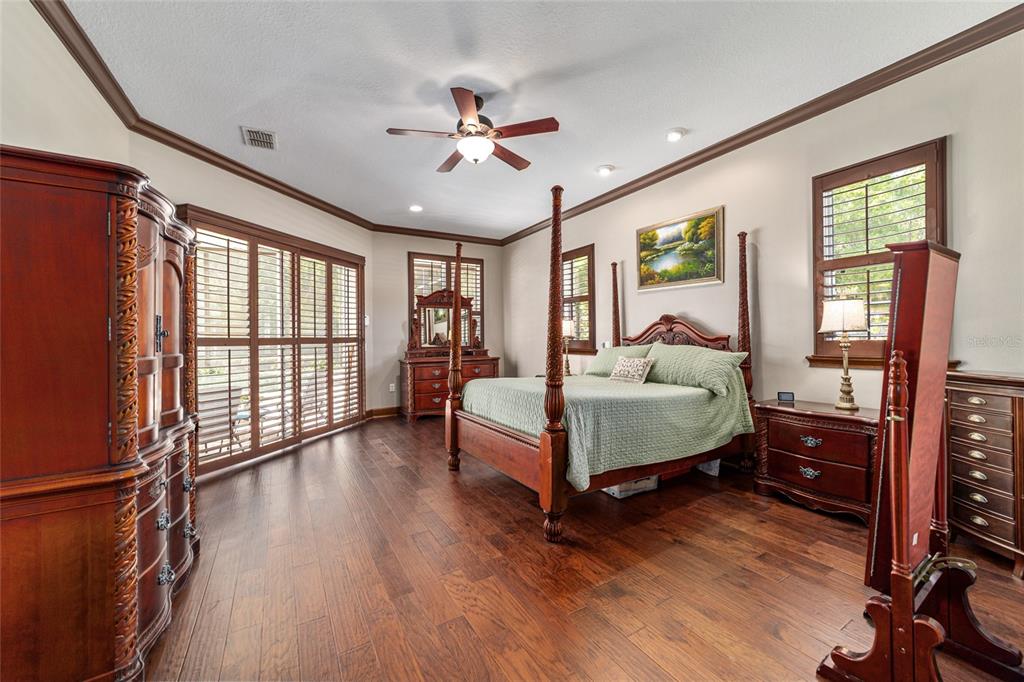 678 Southeast 47th Loop Ocala, FL 34480 - Photo 30 of 73 a spacious bedroom with a bed and a chandelier