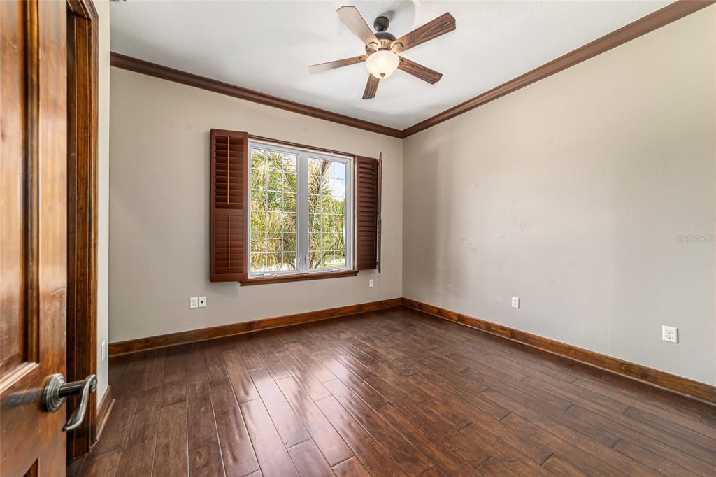 678 Southeast 47th Loop Ocala, FL 34480 - Photo 52 of 73 an empty room with wooden floor chandelier fan and windows