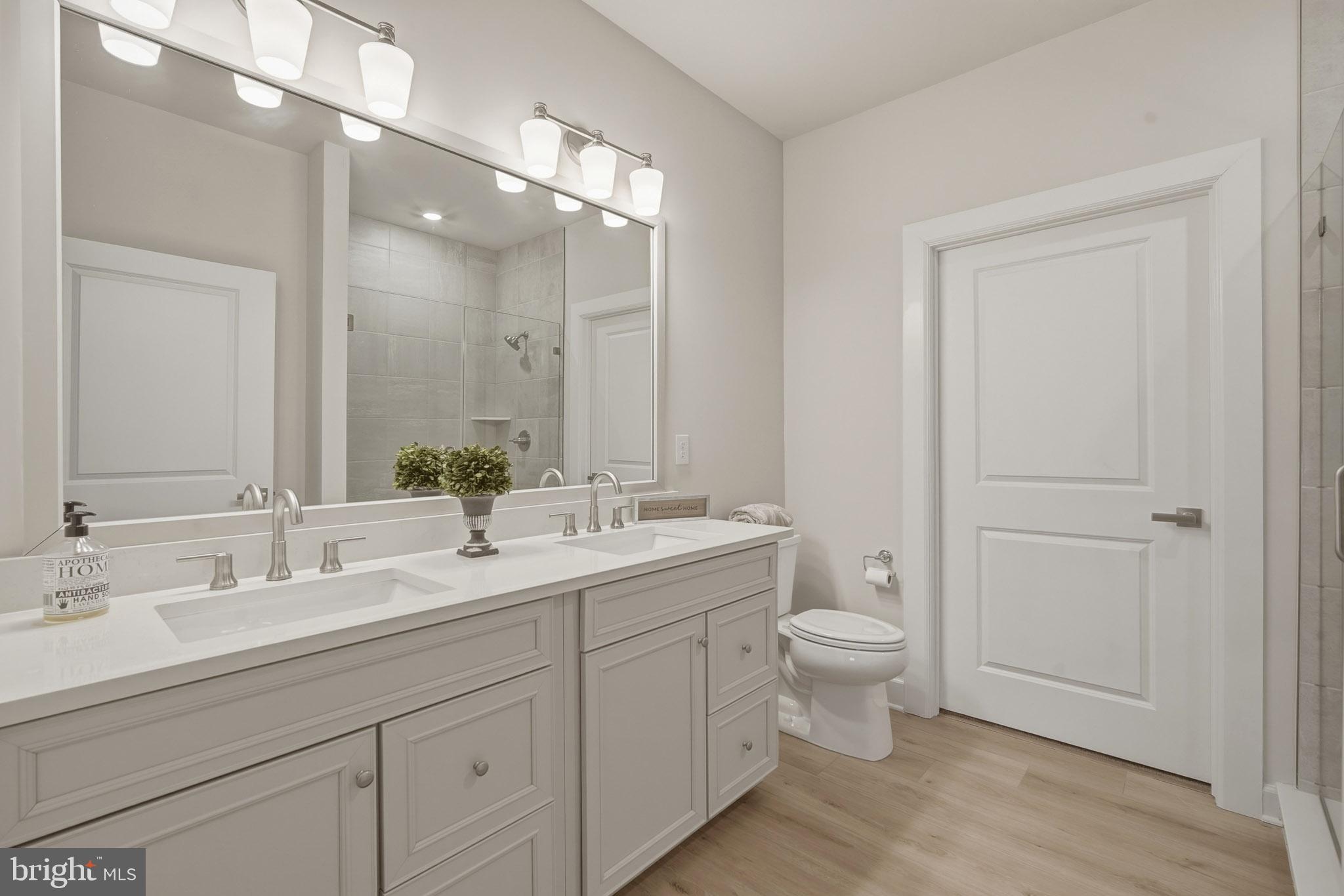 303 Southgate Road Cape May Court House, NJ 08210 - Photo 11 of 25 a bathroom with a double vanity sink toilet and a mirror