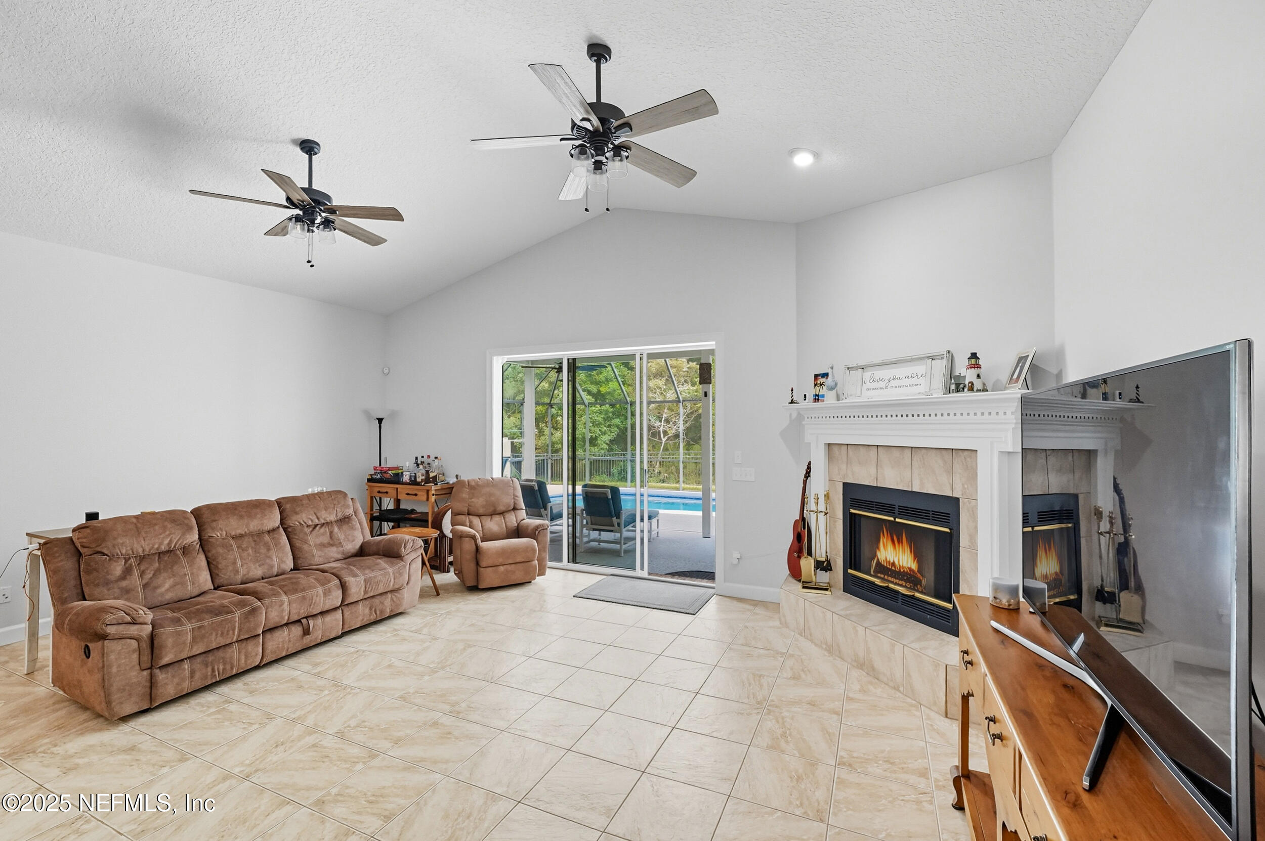 3761 Golden Reeds Lane Jacksonville, FL 32224 - Photo 11 of 40 a living room with furniture a fireplace and a flat screen tv
