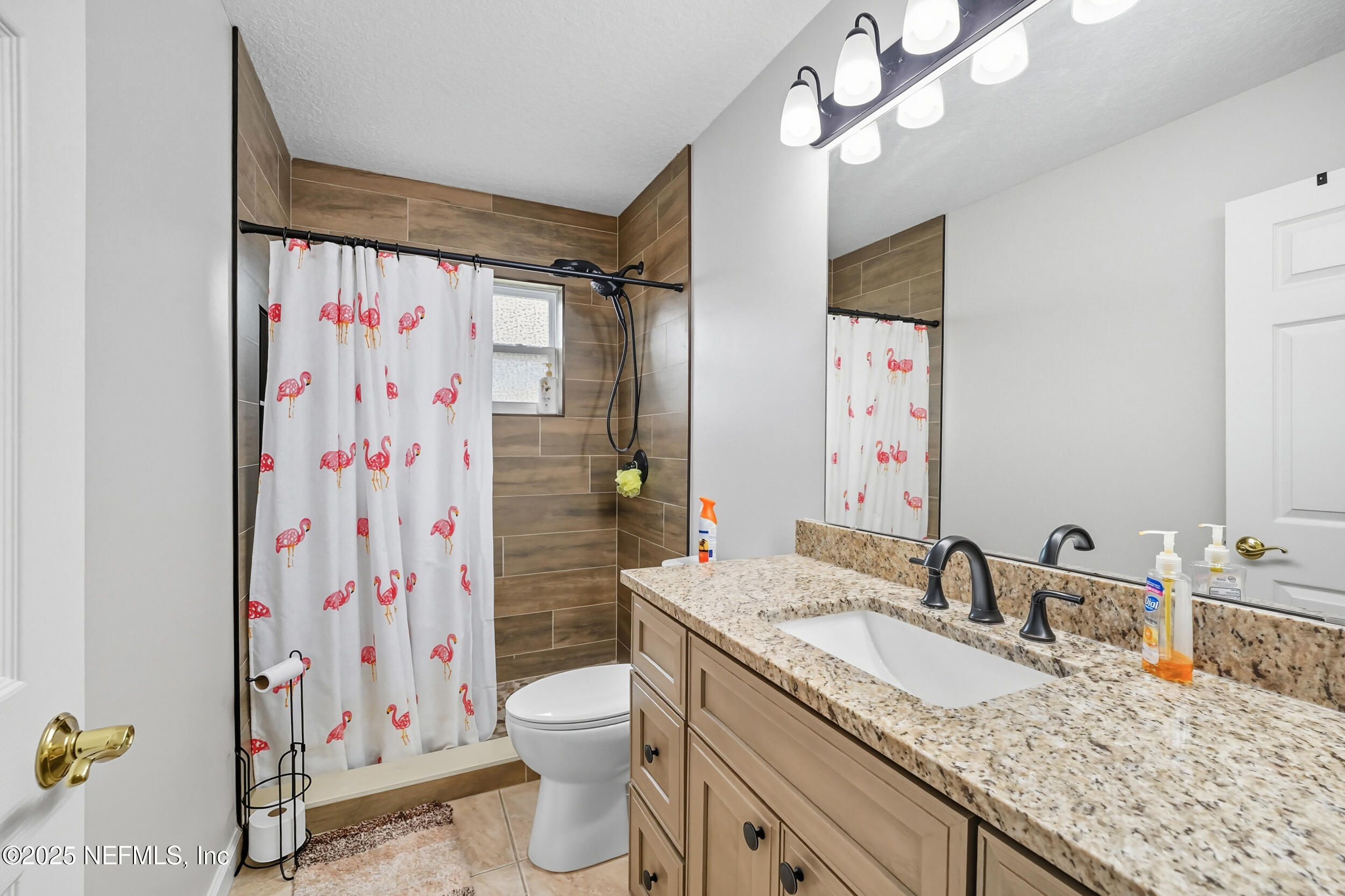 3761 Golden Reeds Lane Jacksonville, FL 32224 - Photo 20 of 40 a bathroom with a granite countertop sink a toilet and shower curtain
