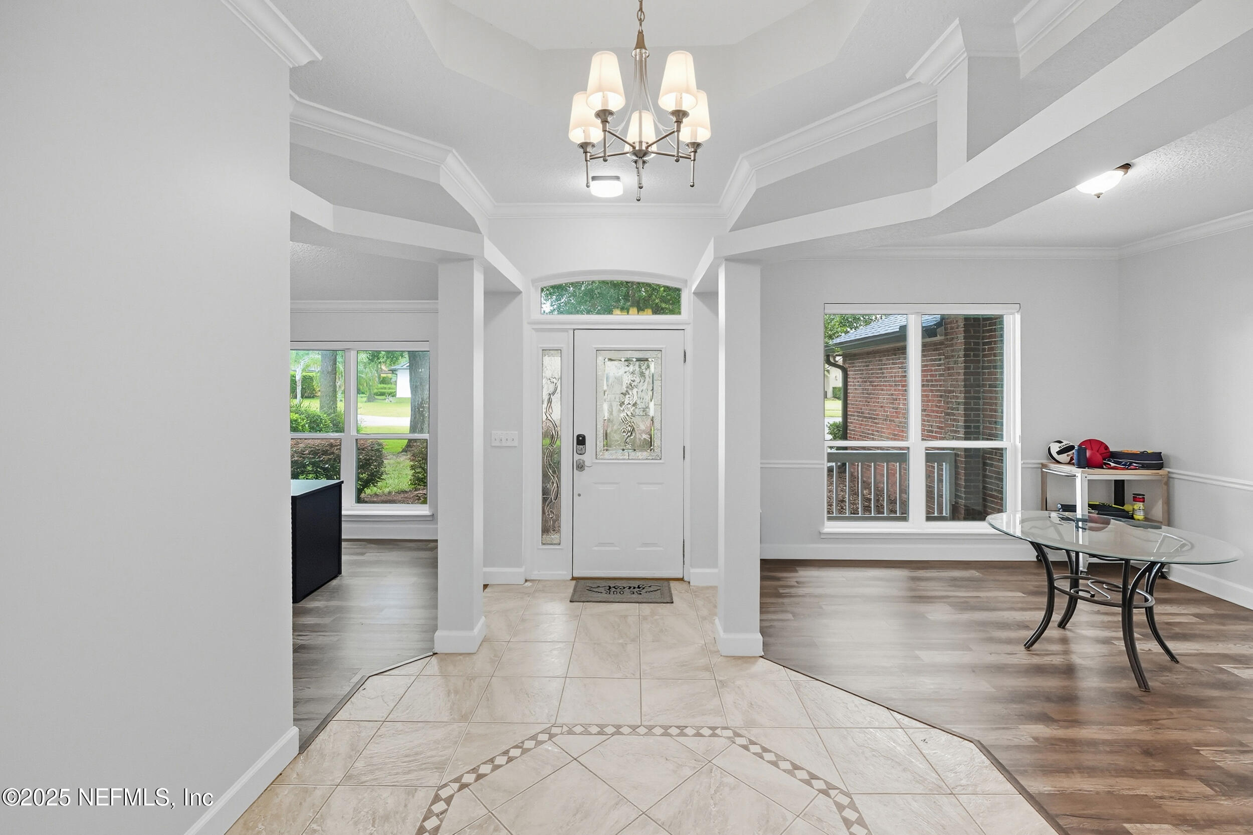3761 Golden Reeds Lane Jacksonville, FL 32224 - Photo 3 of 40 a view of a hallway with wooden floor and a chandelier