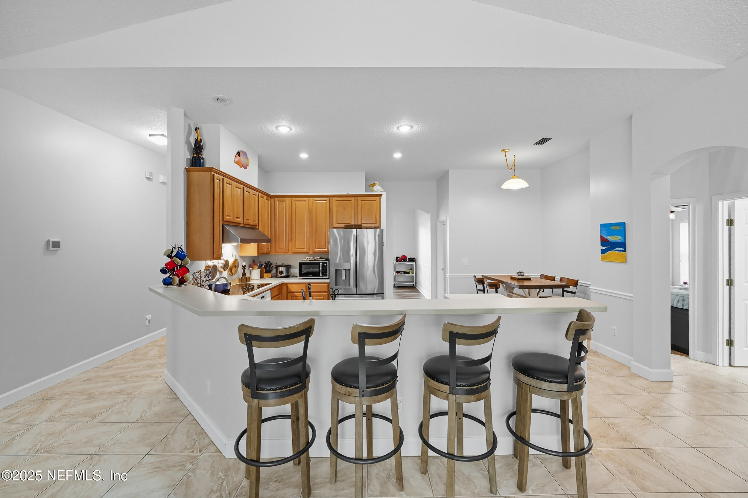 3761 Golden Reeds Lane Jacksonville, FL 32224 - Photo 6 of 40 a kitchen with a dining table chairs stainless steel appliances and cabinets
