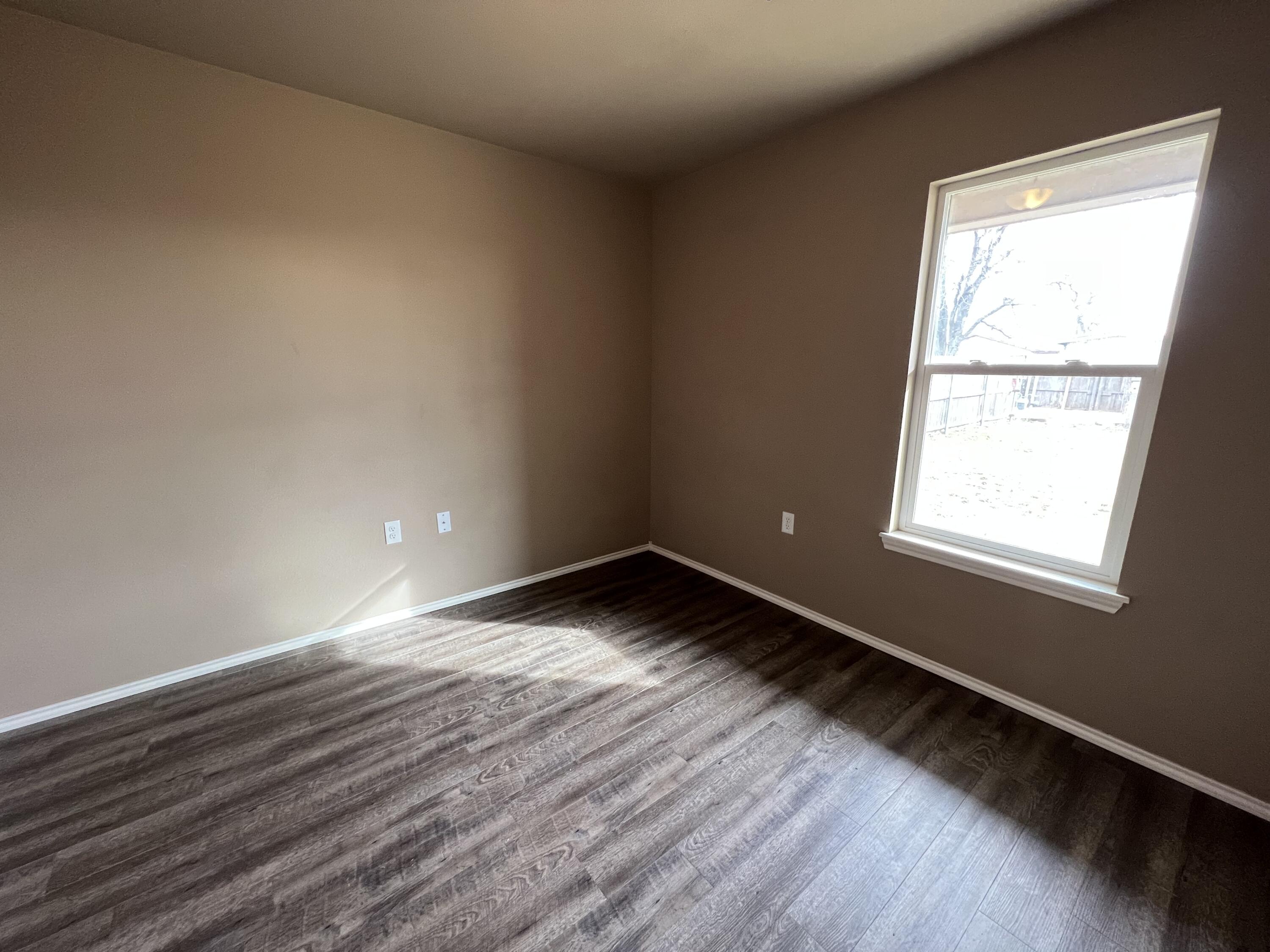 2914 East Cornell Street Lubbock, TX 79403 - Photo 11 of 18 a view of an empty room and wooden floor and a window