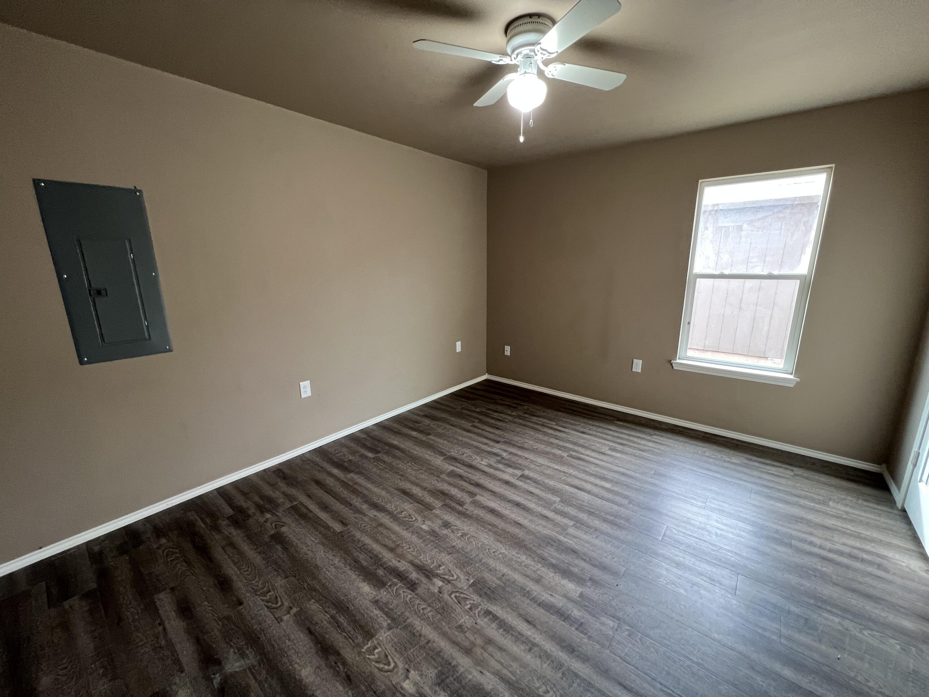 2914 East Cornell Street Lubbock, TX 79403 - Photo 14 of 18 an empty room with wooden floor fan and windows