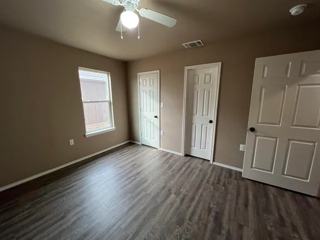 an empty room with wooden floor and window