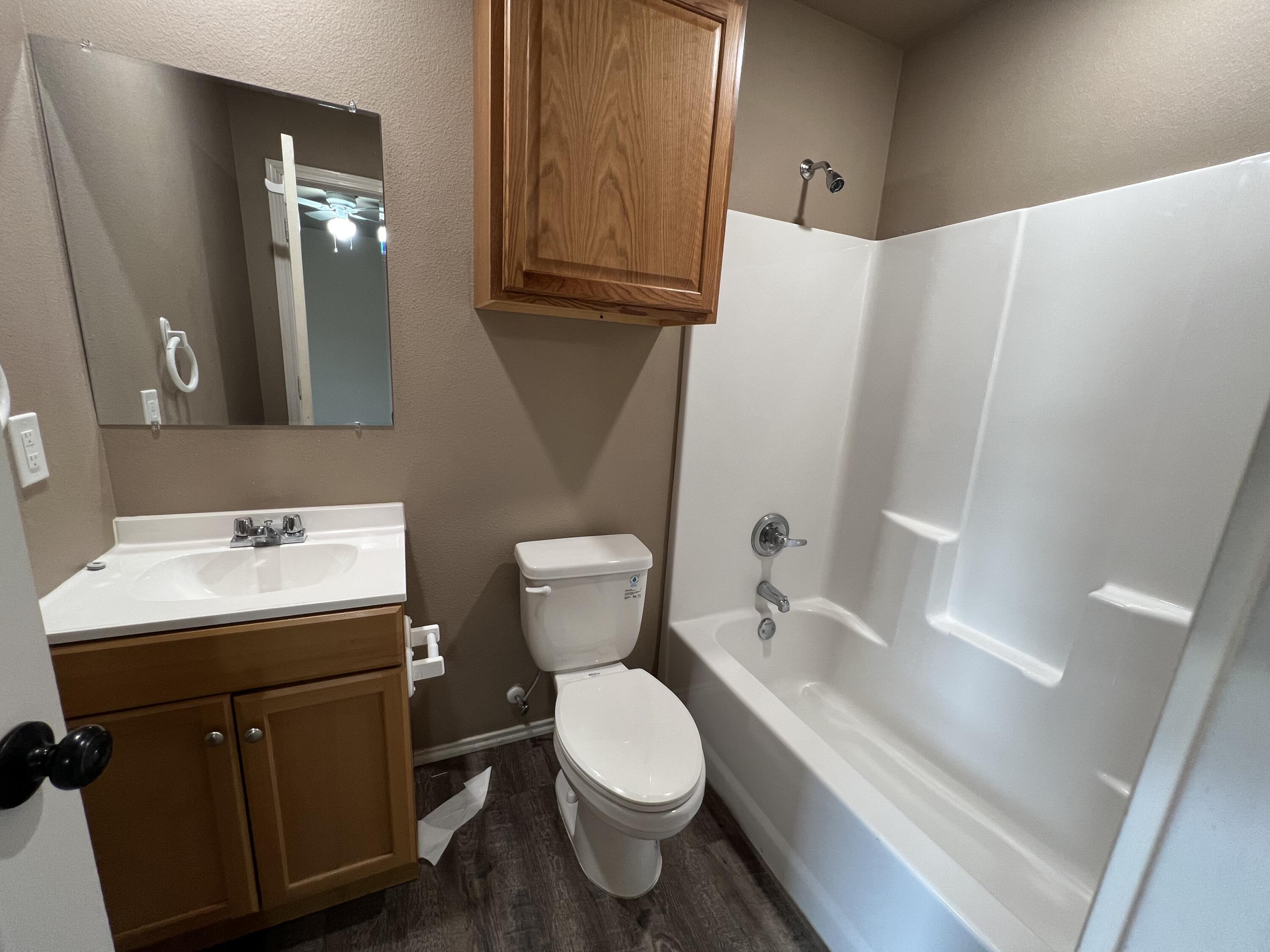 2914 East Cornell Street Lubbock, TX 79403 - Photo 16 of 18 a bathroom with a toilet a sink a tub and mirror